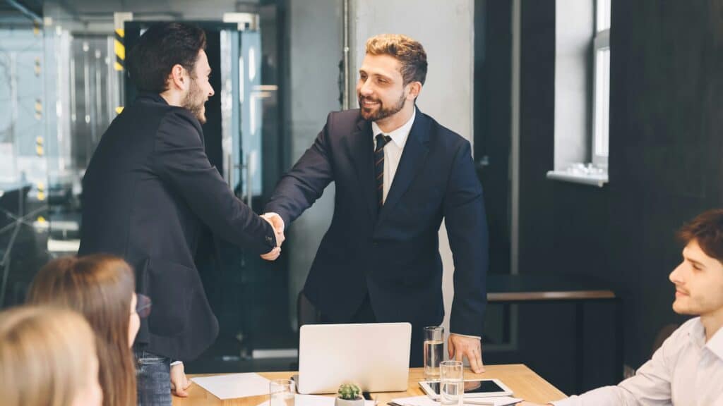Boss shaking hands with business partner, finishing up meeting